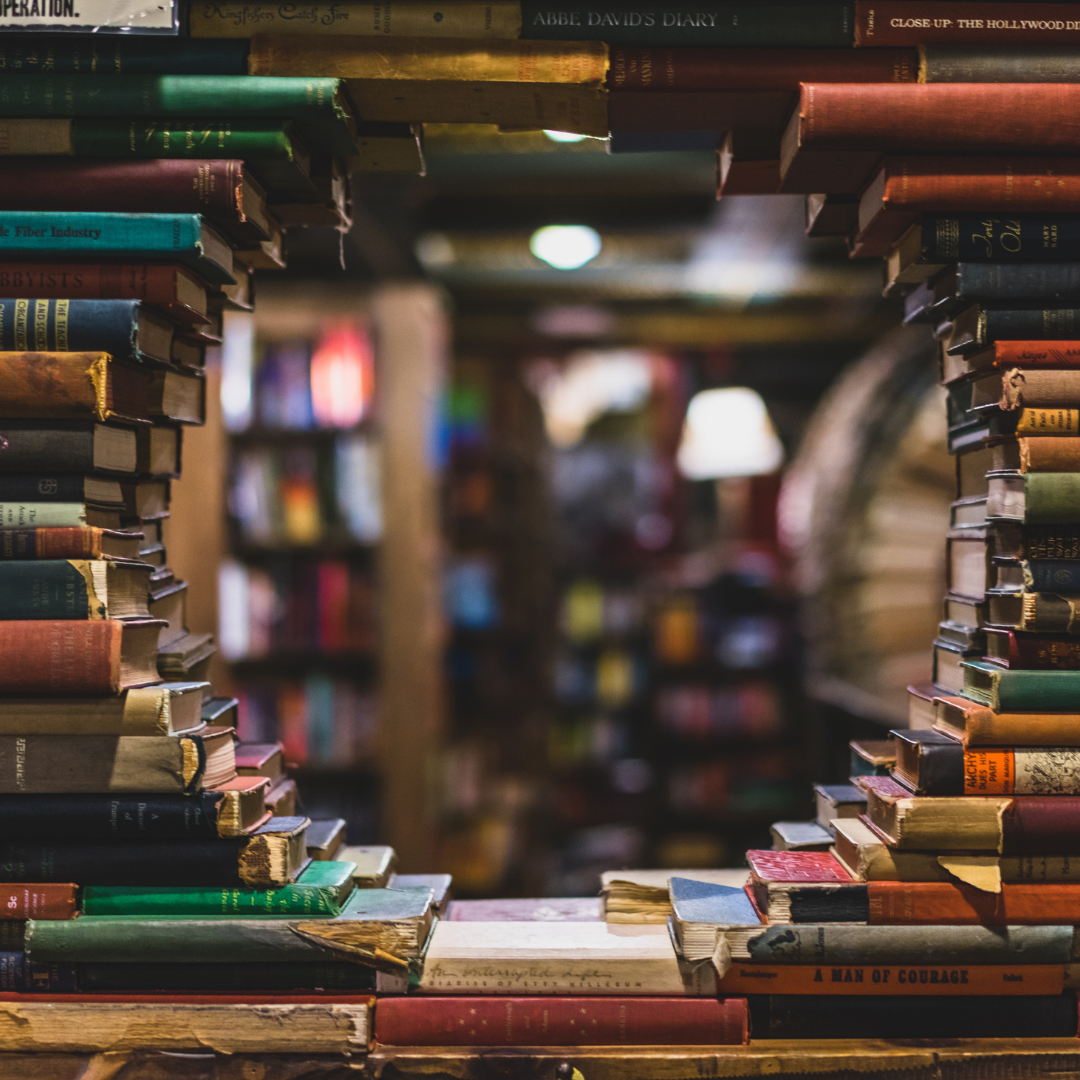 Stacked books creating a window to view a library