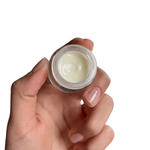 Hand holding small jar of cream