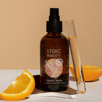 Tangerine oil cleanser with citrus fruit and test tube.